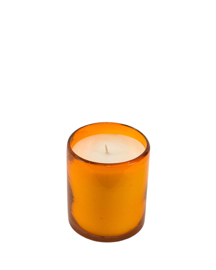 Summer Hours 80° candle in an orange glass on a white background